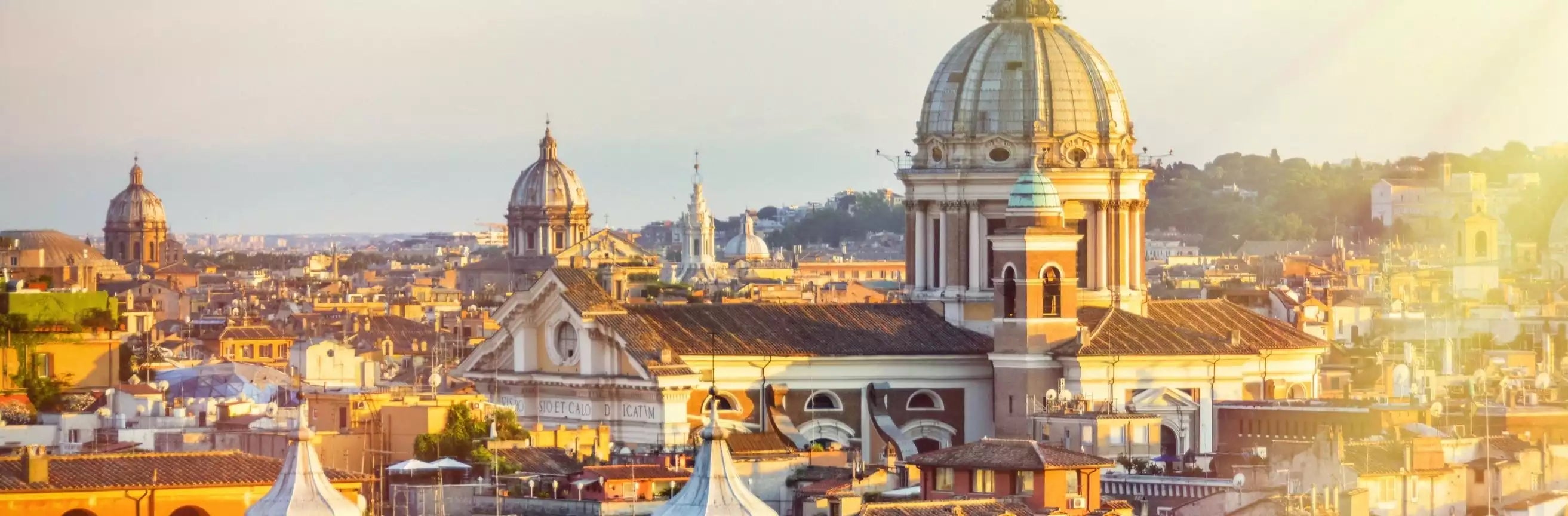 Cityscape with prominent domes and buildings bathed in warm sunlight.