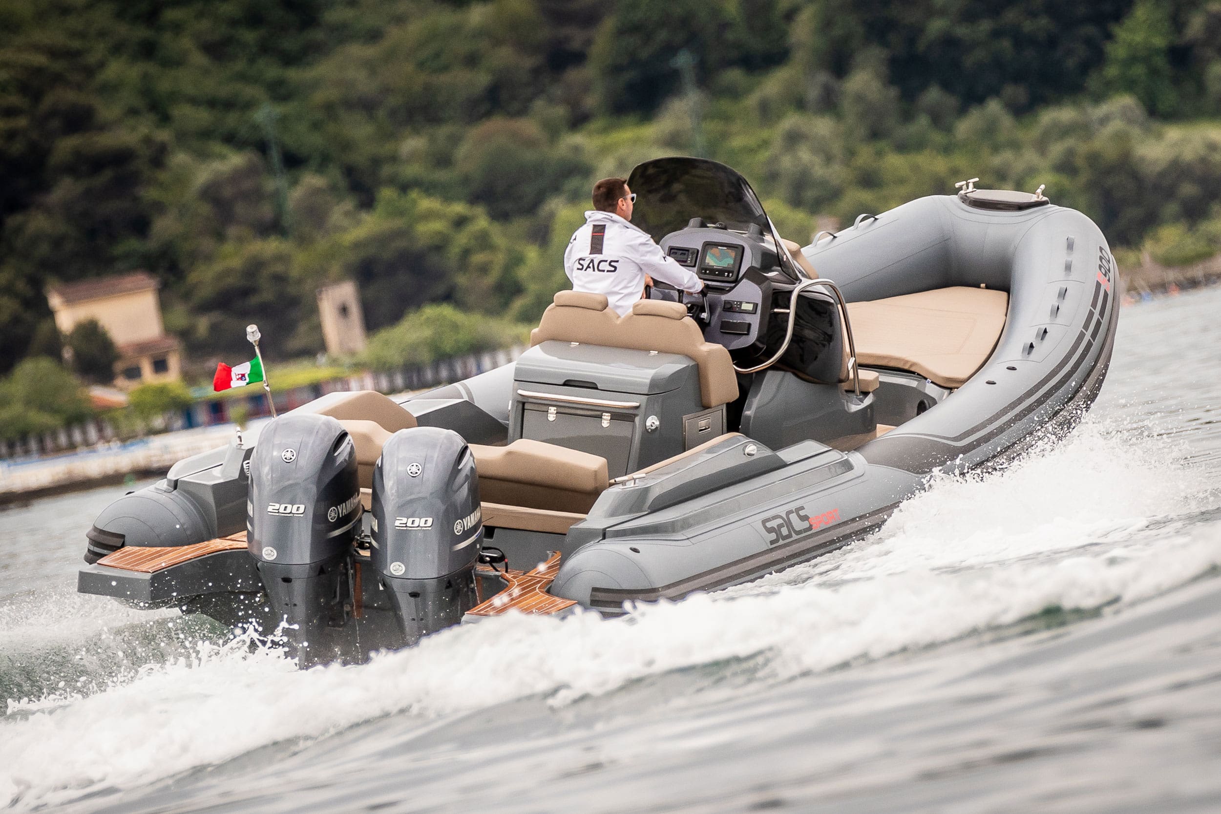 Inflatable boat with outboard motors on a body of water with a scenic background