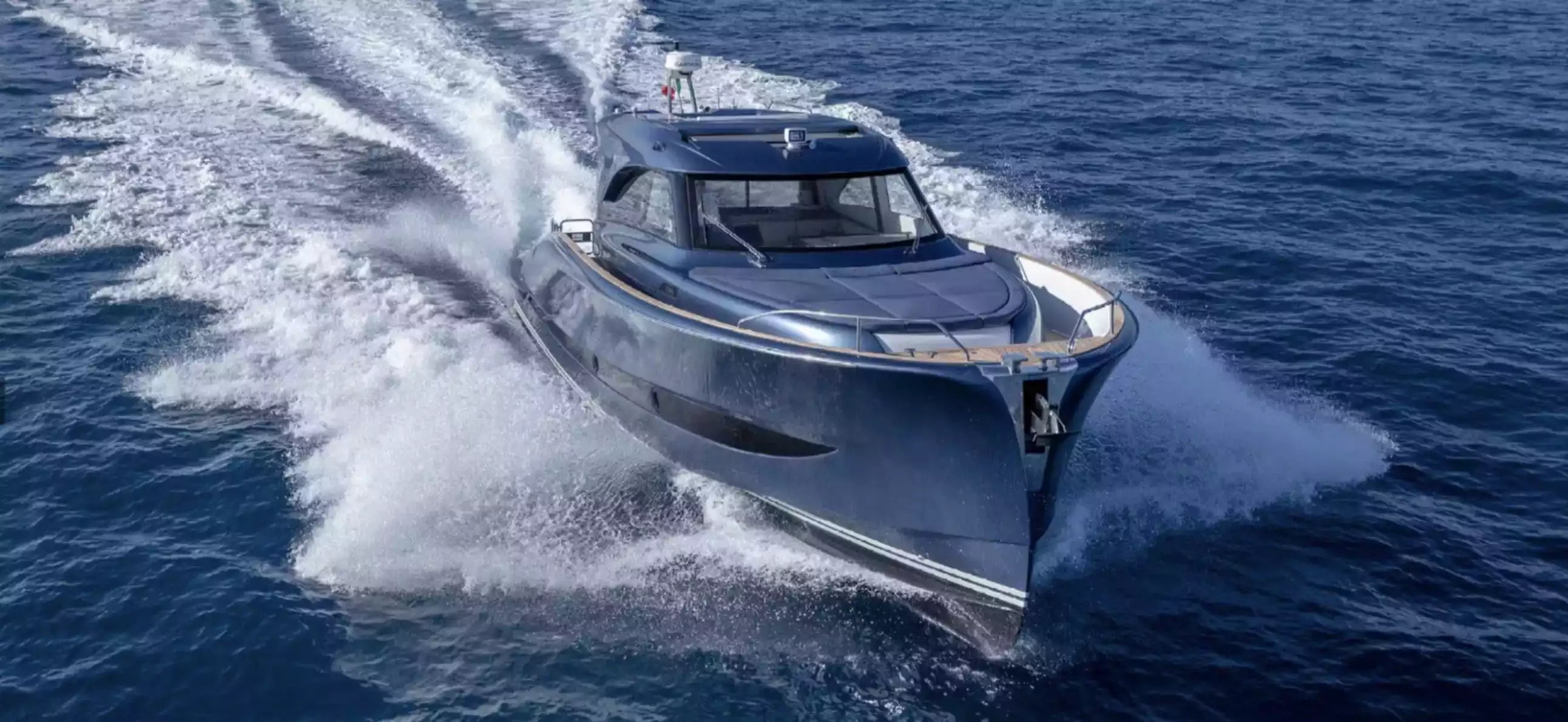 Blue speedboat cutting through the water on a clear day