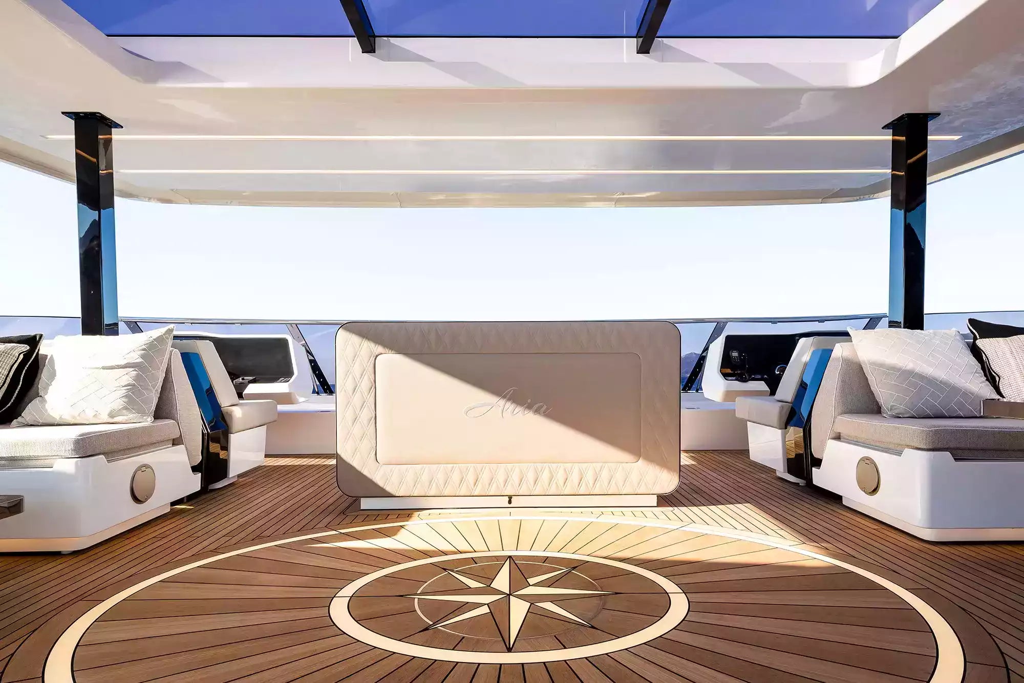 Luxury yacht interior with white sofas and a wooden floor.