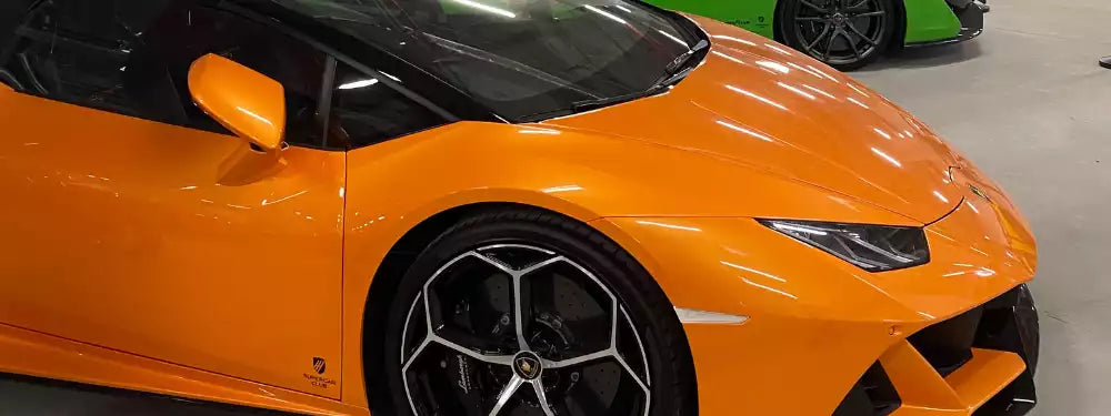 Orange sports car in a showroom setting