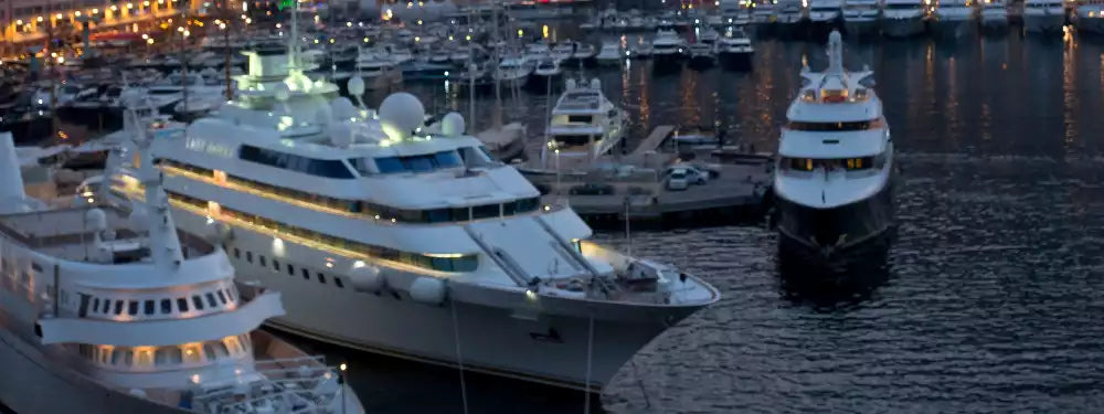 Large yachts docked at a marina at night