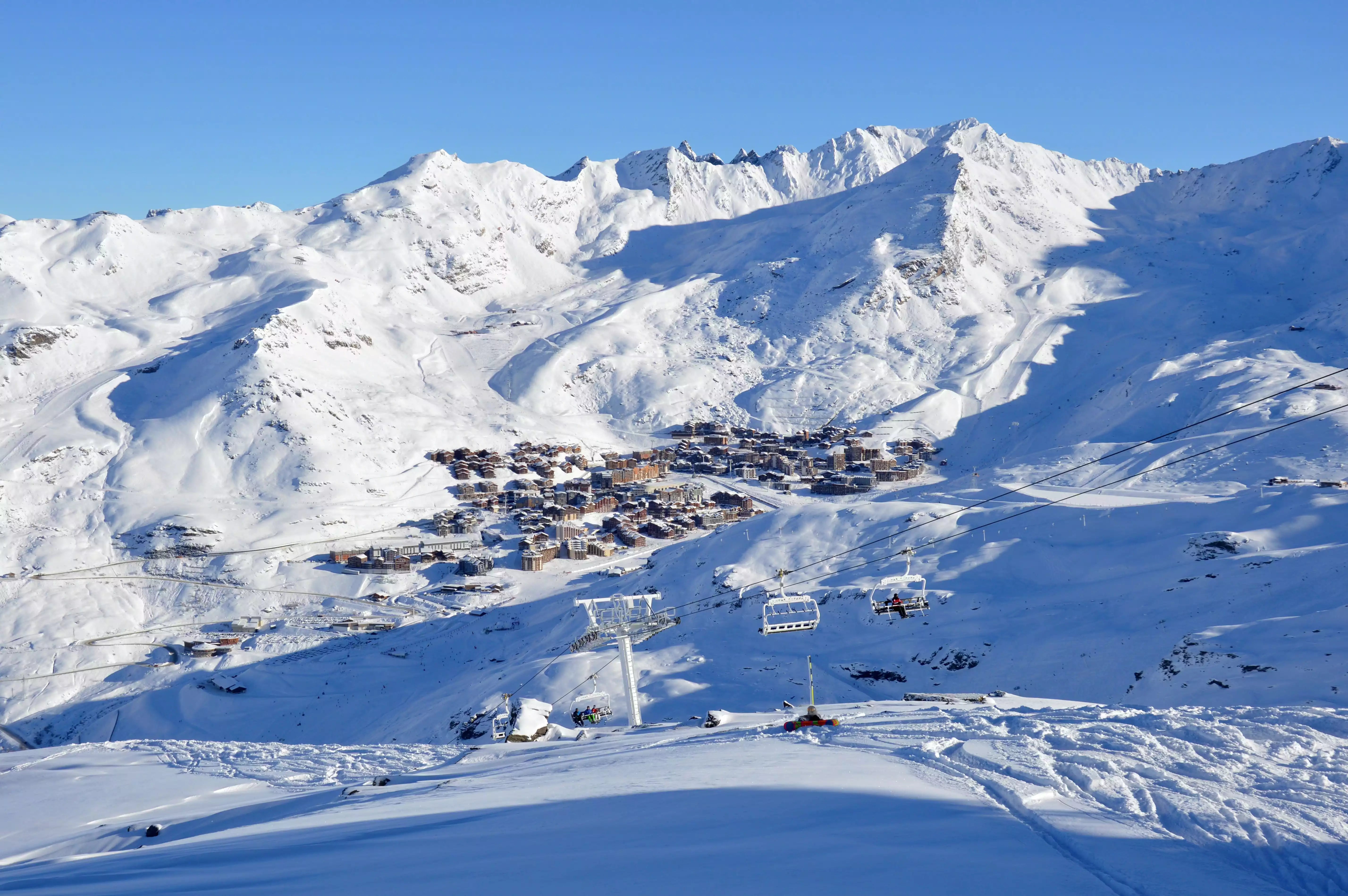 Snow-covered mountain landscape with ski lifts and buildings