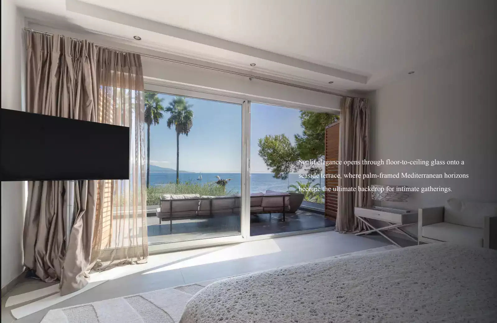 Modern interior with large sliding glass doors leading to a balcony with ocean view.