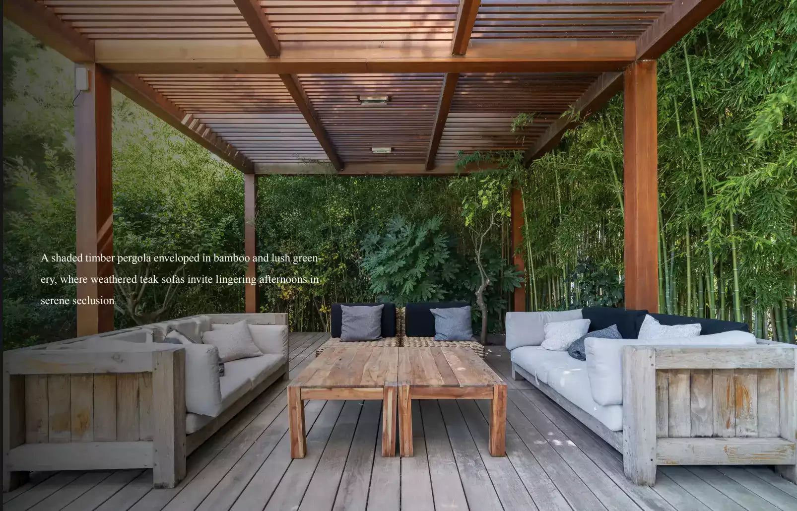 Outdoor patio with wooden pergola, tables, and chairs surrounded by greenery.