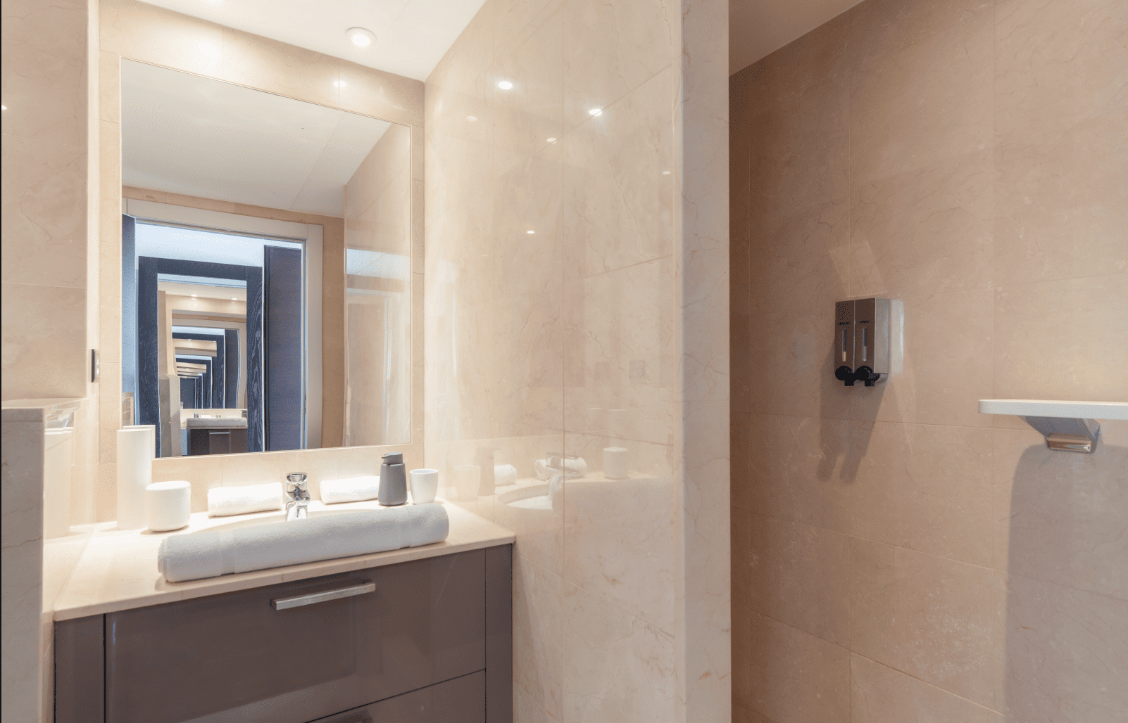 Bathroom interior with beige tiles, sink, and mirror.