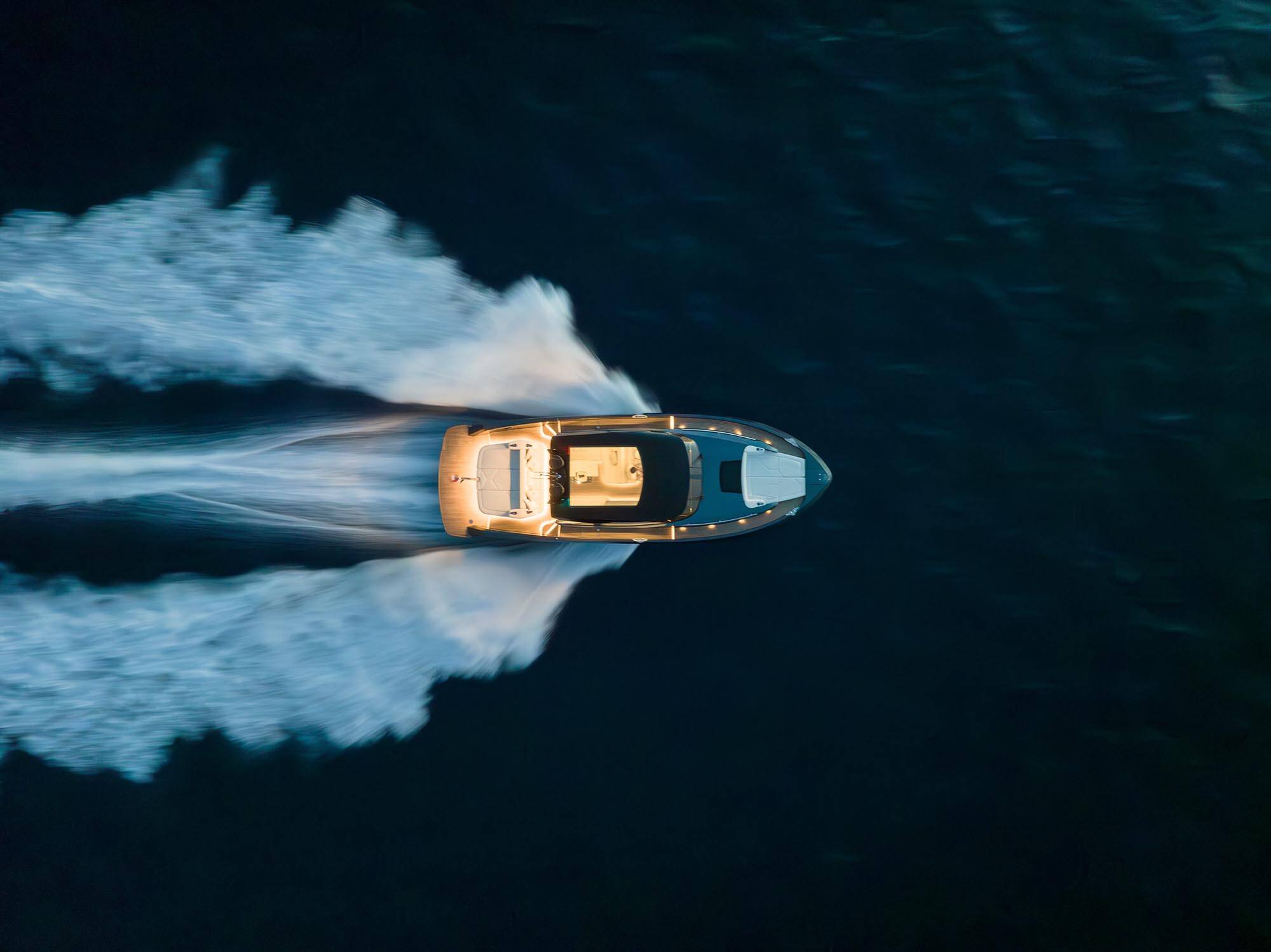 Speedboat leaving a trail of white water on a dark blue ocean