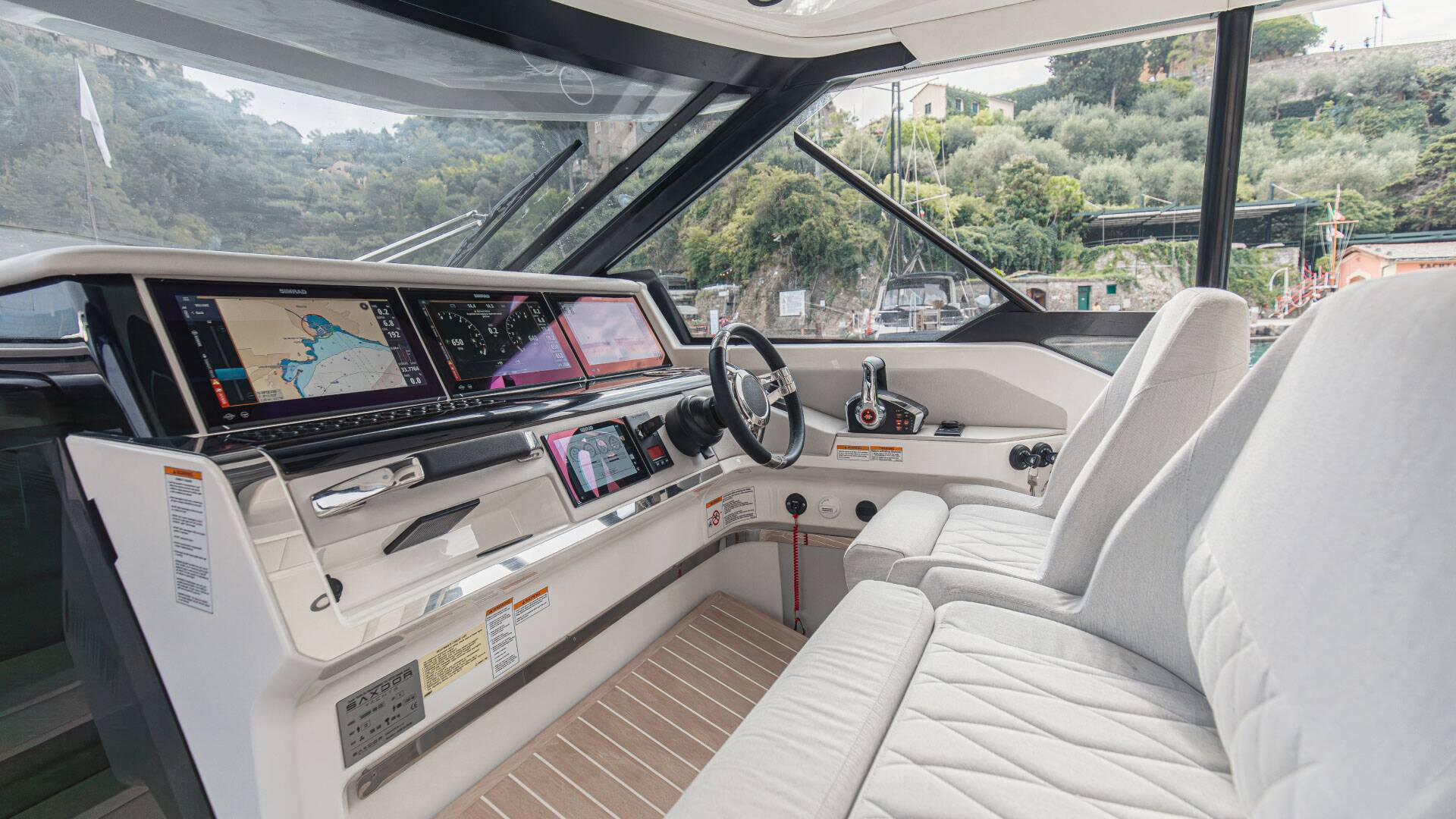 Boat interior with dashboard, steering wheel, and seating area.