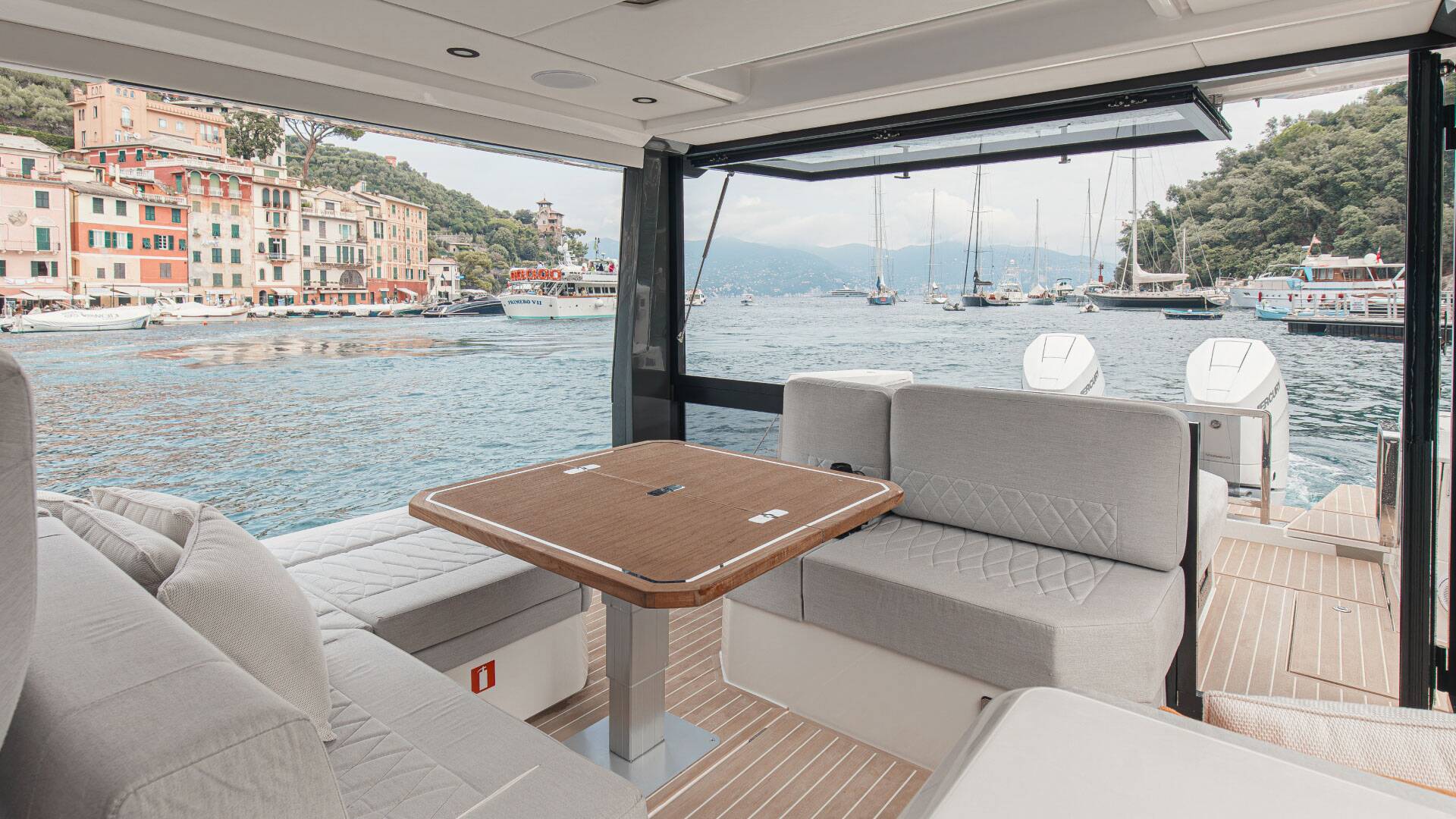 Interior of a luxurious yacht with a view of a coastal town and harbor.