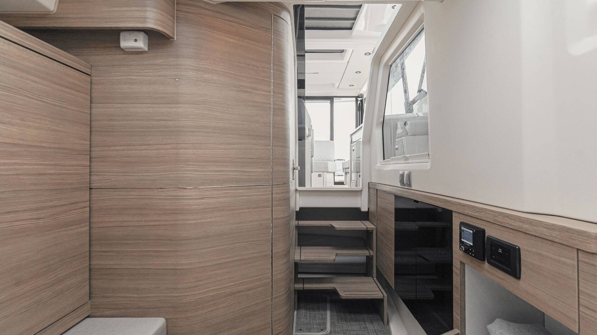 Interior of a modern vehicle with wooden paneling and control panels.