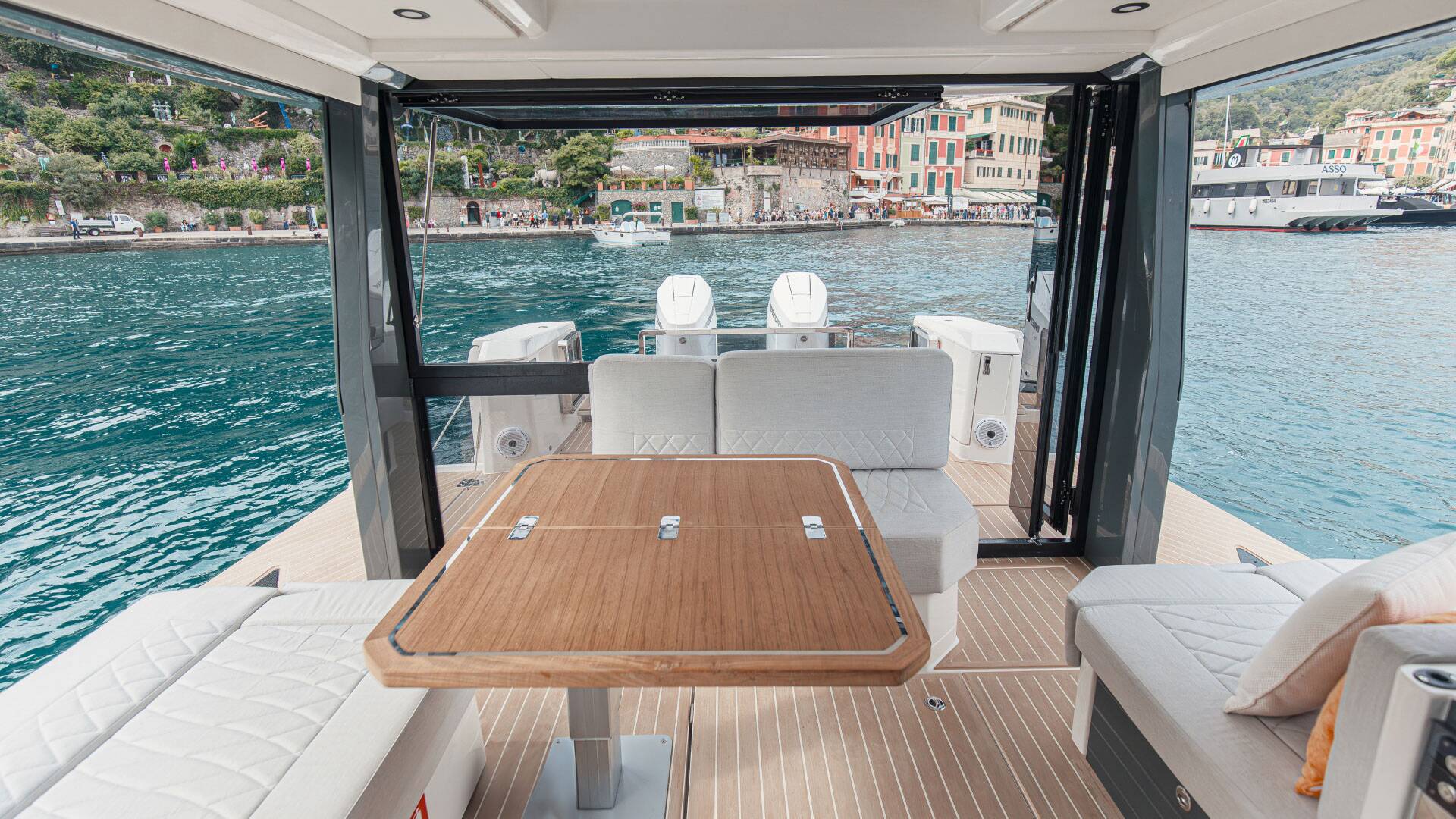 Yacht interior with table and seating area overlooking a waterfront view