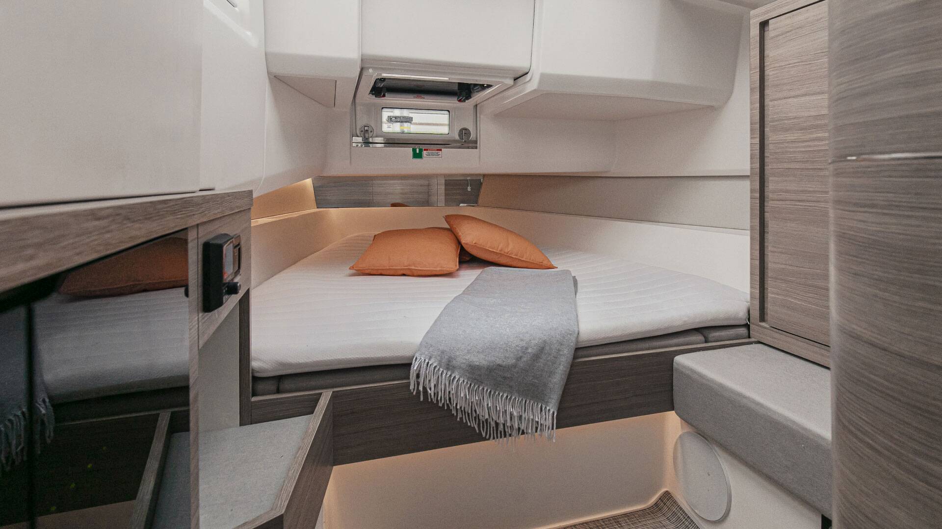 Compact living space with a bed, storage compartments, and a small table.