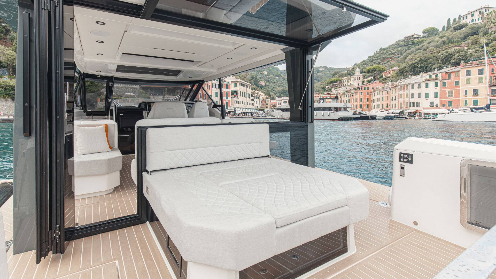 Interior of a luxury yacht with a view of a coastal town.