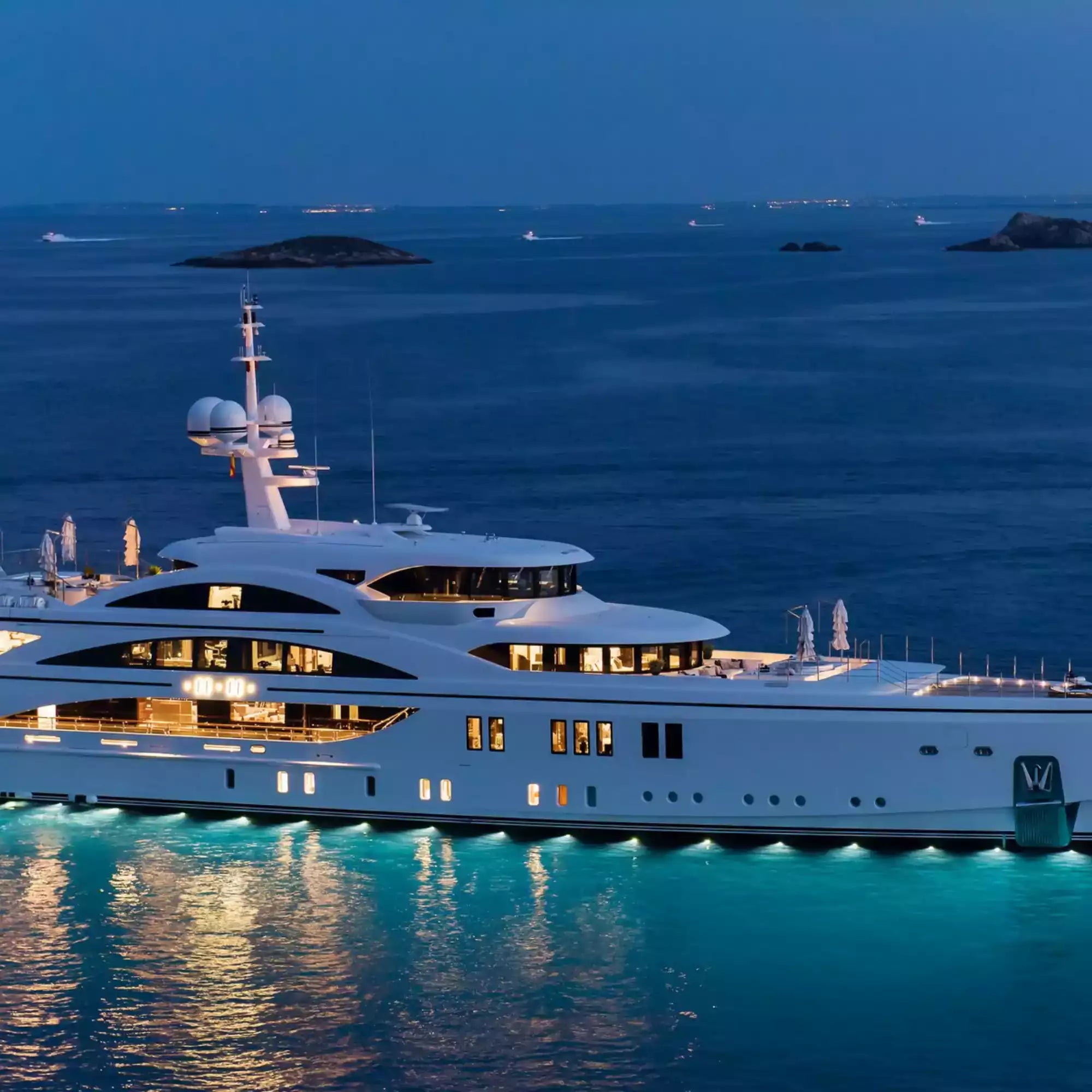 Luxury yacht in the ocean at night with illuminated windows