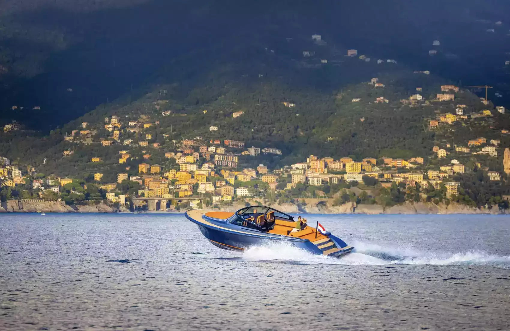 Speedboat on a body of water with a mountainous landscape in the background