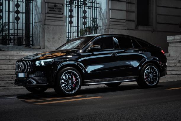 Black Mercedes-Benz SUV parked on a street with classical architecture in the background