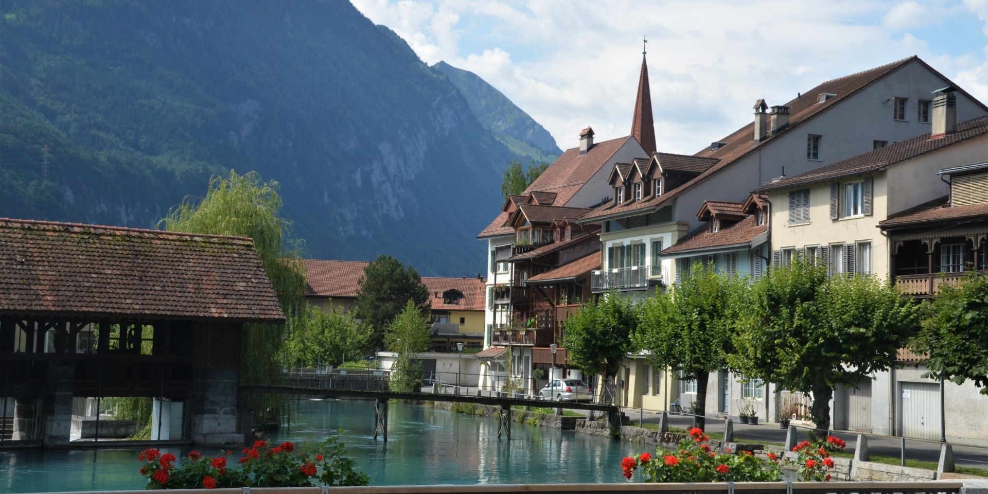 Town with a covered bridge and mountains in the background
